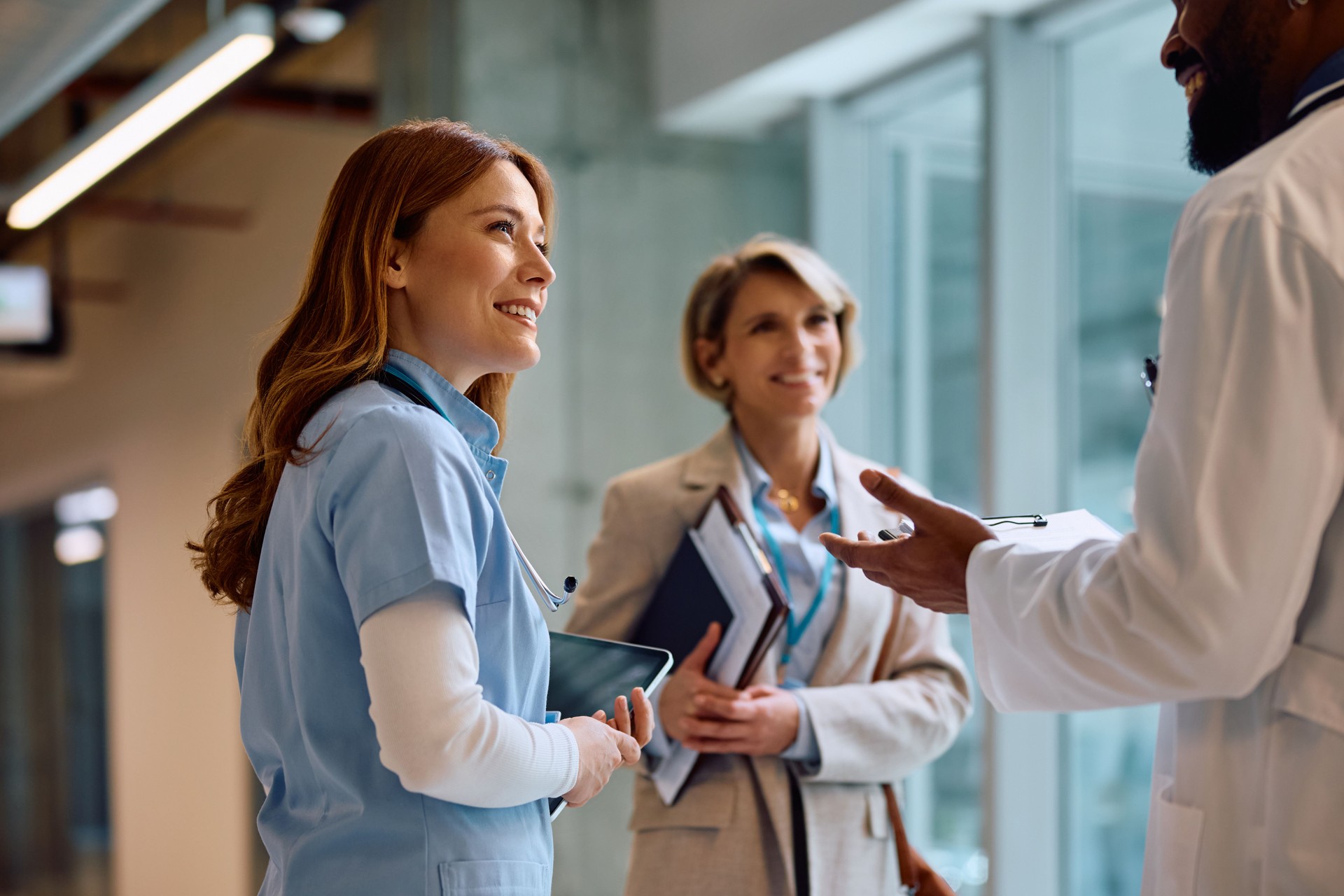 Happy nurse on a meeting with hospital administrator and doctor. Happy nurse on a meeting with hospital administrator and doctor.